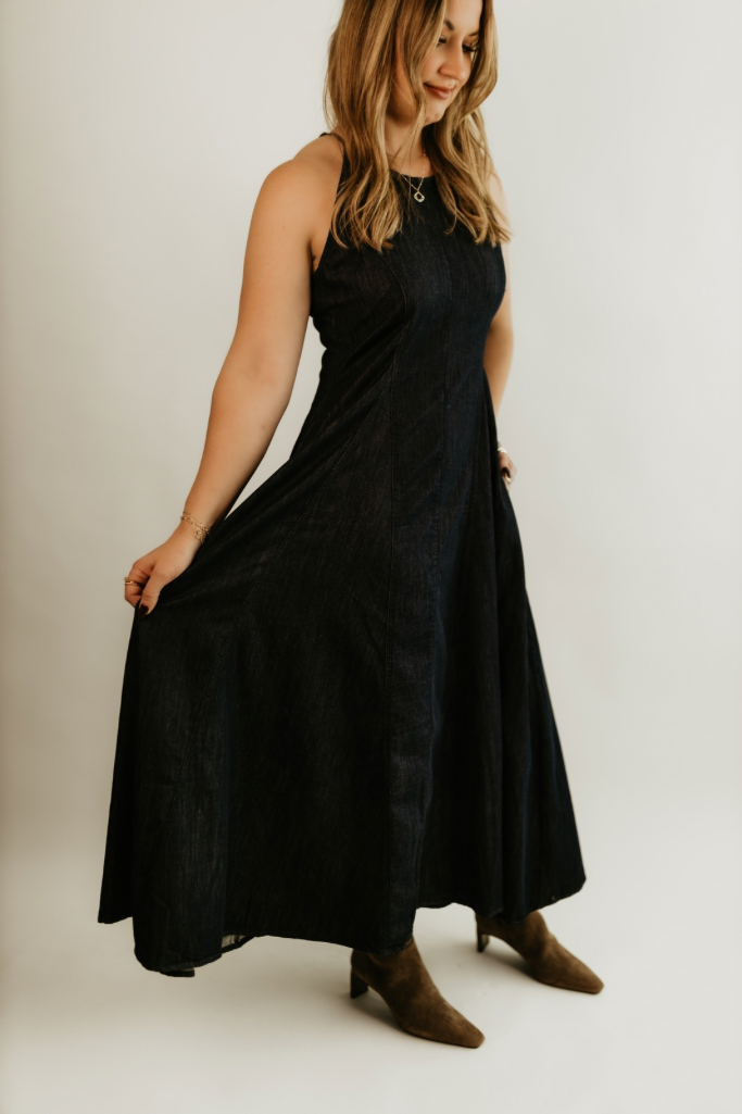 Woman wearing The Rowan Denim Midi Dress, a halter shaped, classic flowing dress with pockets, by Studio Hill Designs.