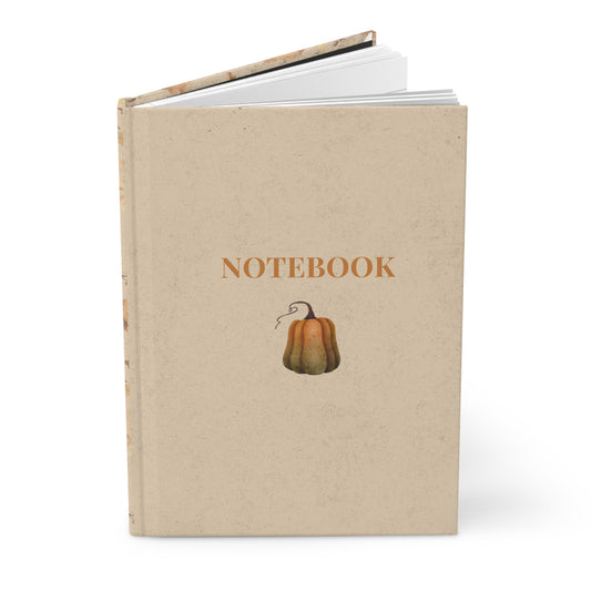 Notebook with pumpkin design and 'Notebook' text on a beige background designed by Studio Hill Designs.