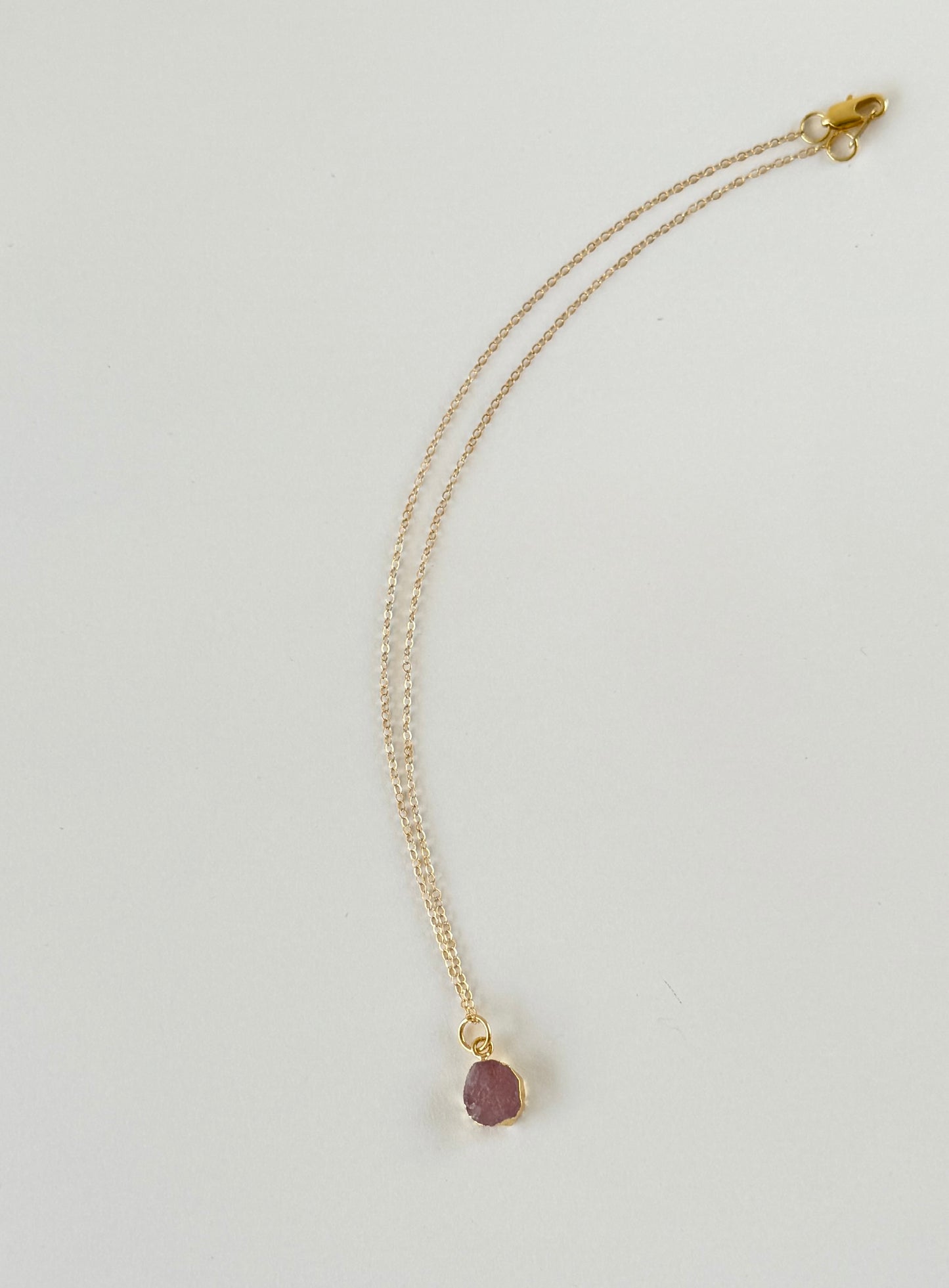 Handmade gold filled necklace with pink natural pendant on mannequin by studio hill designs.