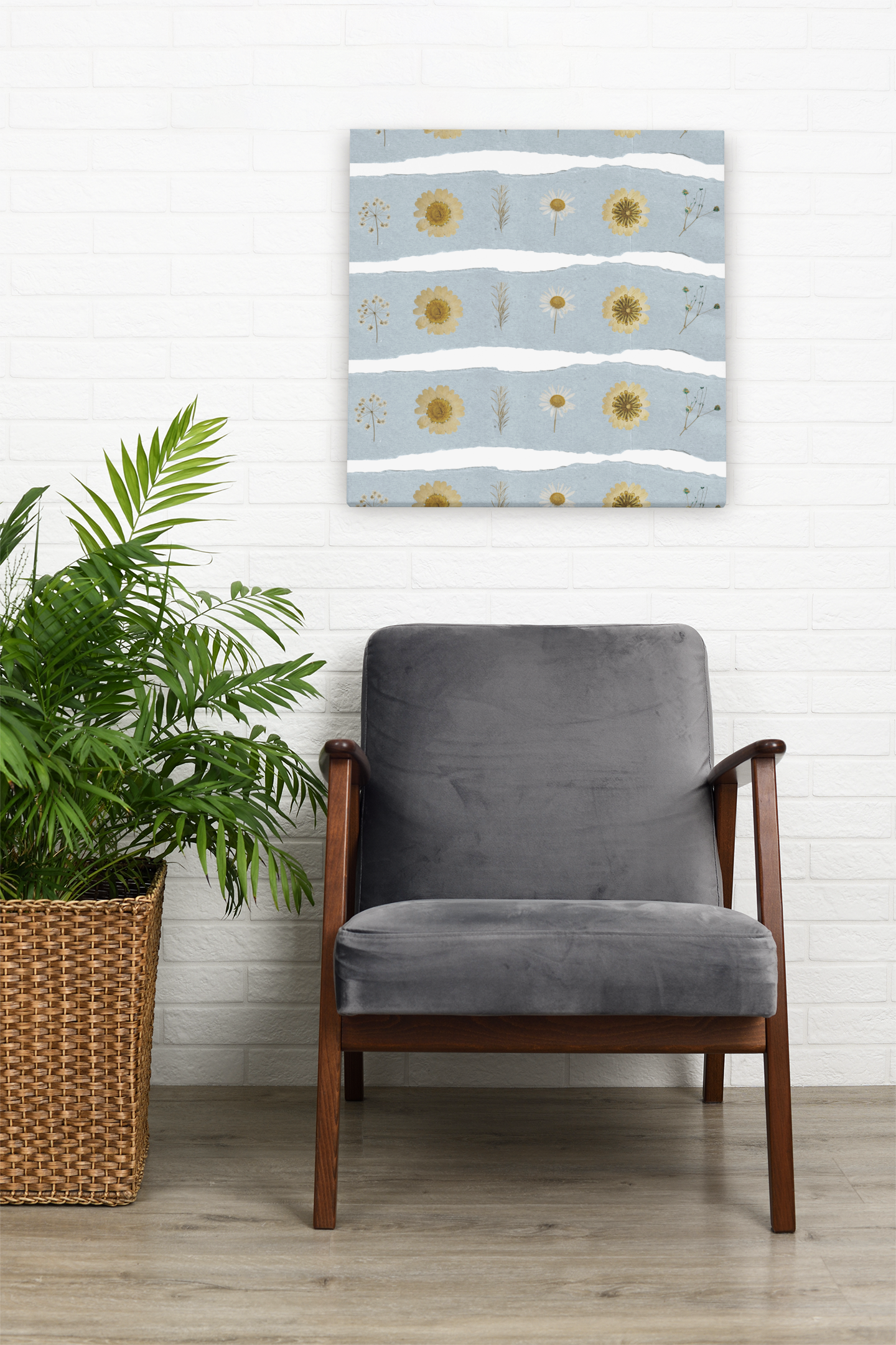 Mockup of wildflower botanical wall art created by Studio Hill Designs on a white wall behind a grey chair.