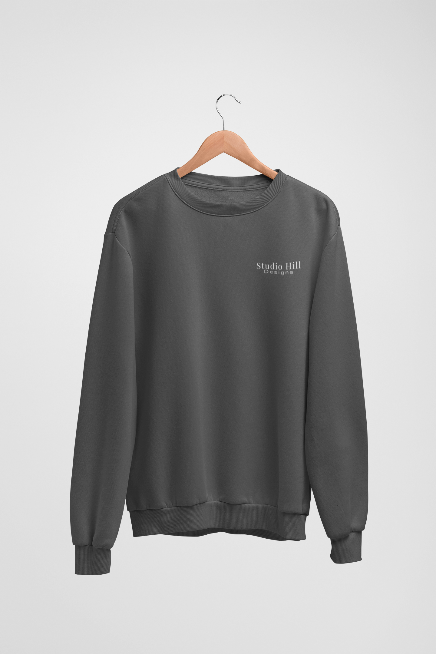 Studio Hill Designs unisex gray crew sweatshirt with text on a hanger against a white background