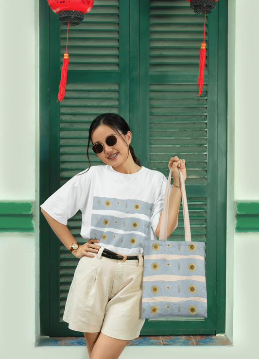 mockup of woman smiling holding wildflower tote bag and wearing the matching wildflower t by studio hill designs