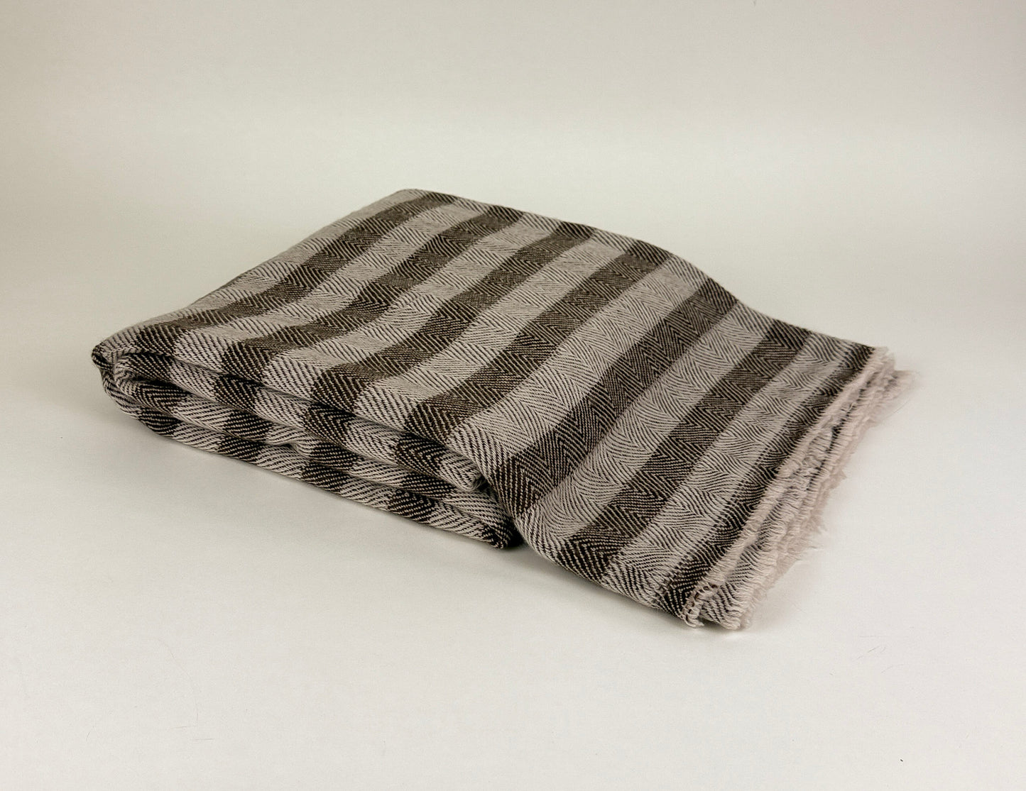 The Hamilton Cashmere Throw in brown and beige folded on a white background by Studio Hill Designs.