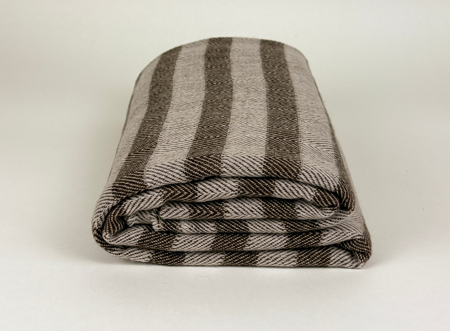The Hamilton Cashmere Throw in brown and beige folded on a white background by Studio Hill Designs.