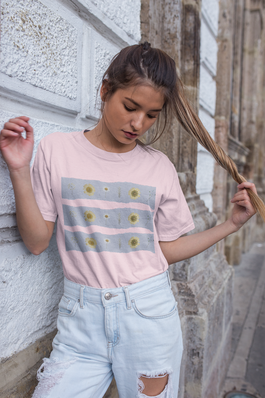 Mockup of a woman wearing the pink oversized wildflower graphic tee featuring blue stripes with rows of sunflowers and wildflowers by Studio Hill Designs 