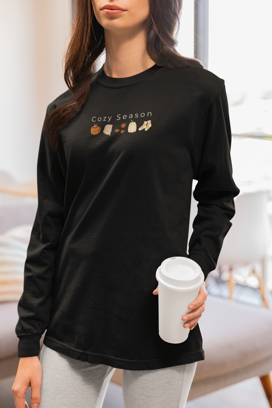 Person wearing a black long-sleeve shirt with 'Cozy Season' text and fall themed graphic designed by Studio Hill Designs